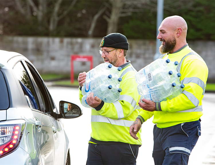 Helping by giving out bottles of water