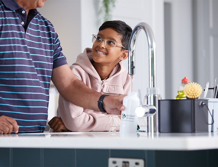 Father and son filling up water bottle from tap